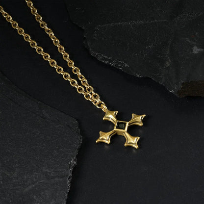 Gold Black Testament Necklace laid across black textured fabric with the gothic cross pendant in view.