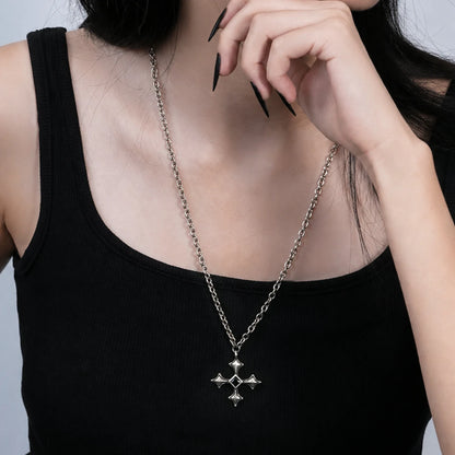 Black Testament Necklace in antiqued silver worn over a black top with a hand near the face in a front styling crop.