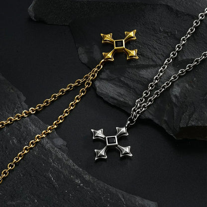 Silver and gold Black Testament Necklaces laid diagonally together on black textured fabric.