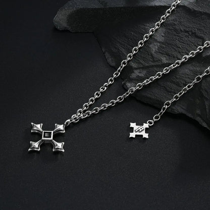 Silver Black Testament Necklace laid across black textured fabric with the gothic cross pendant in view.
