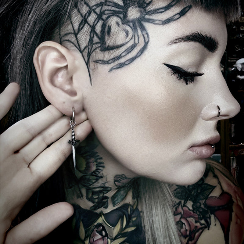 Side view of model wearing a silver Blade Wing earring with a long pointed drop