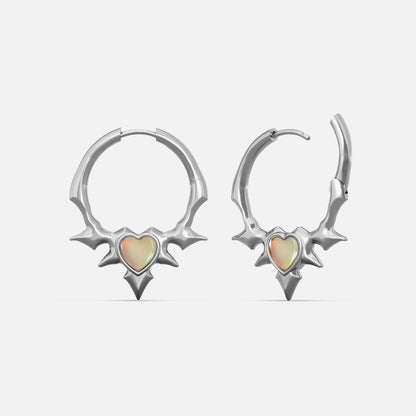 Silver-tone spiked hoop earrings with a heart-shaped opal center, front and side view