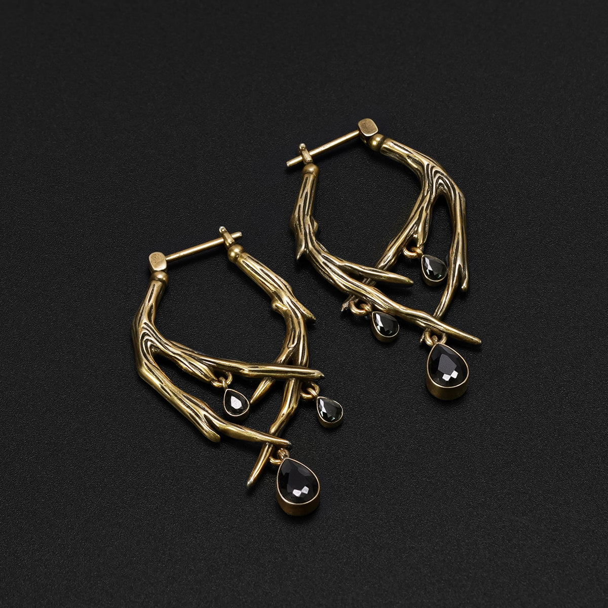 Pair of gold Blood Thorn hoop earrings with branching frames and dark red drops