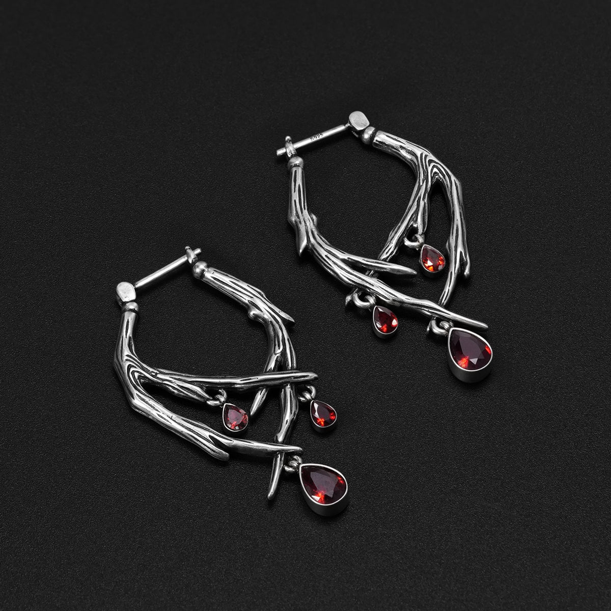 Pair of silver Blood Thorn hoop earrings with branching frames and red drops