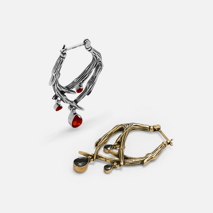 Side-by-side comparison of silver-tone and gold-tone thorn hoop earrings with red and black teardrop crystals