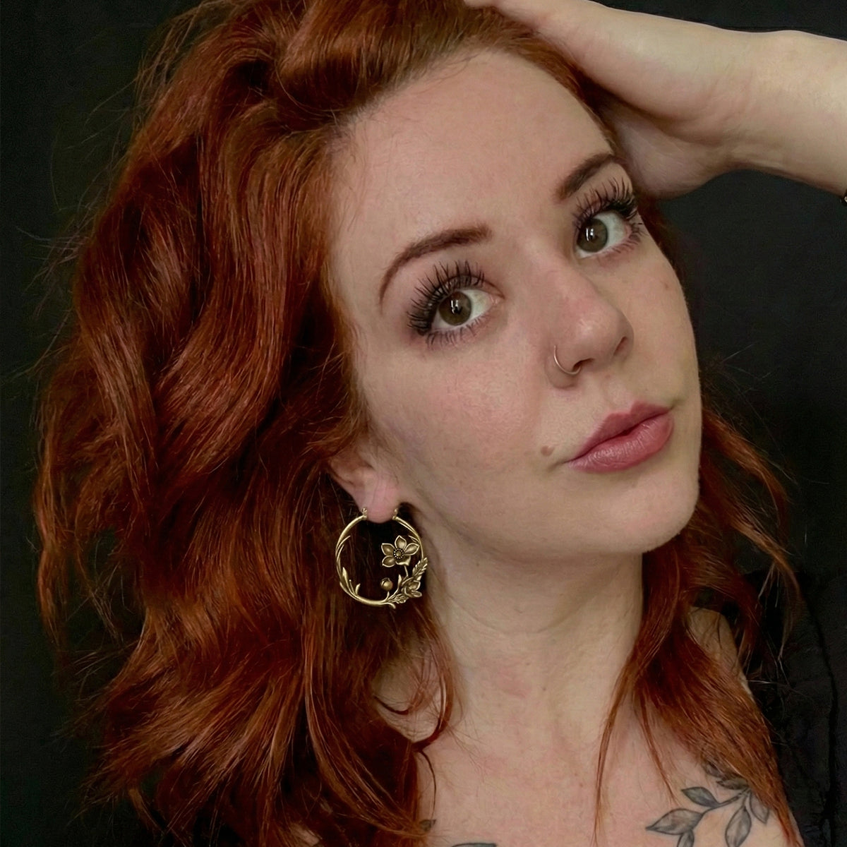 Red-haired model wearing gold Blossoming Vine hoop earrings