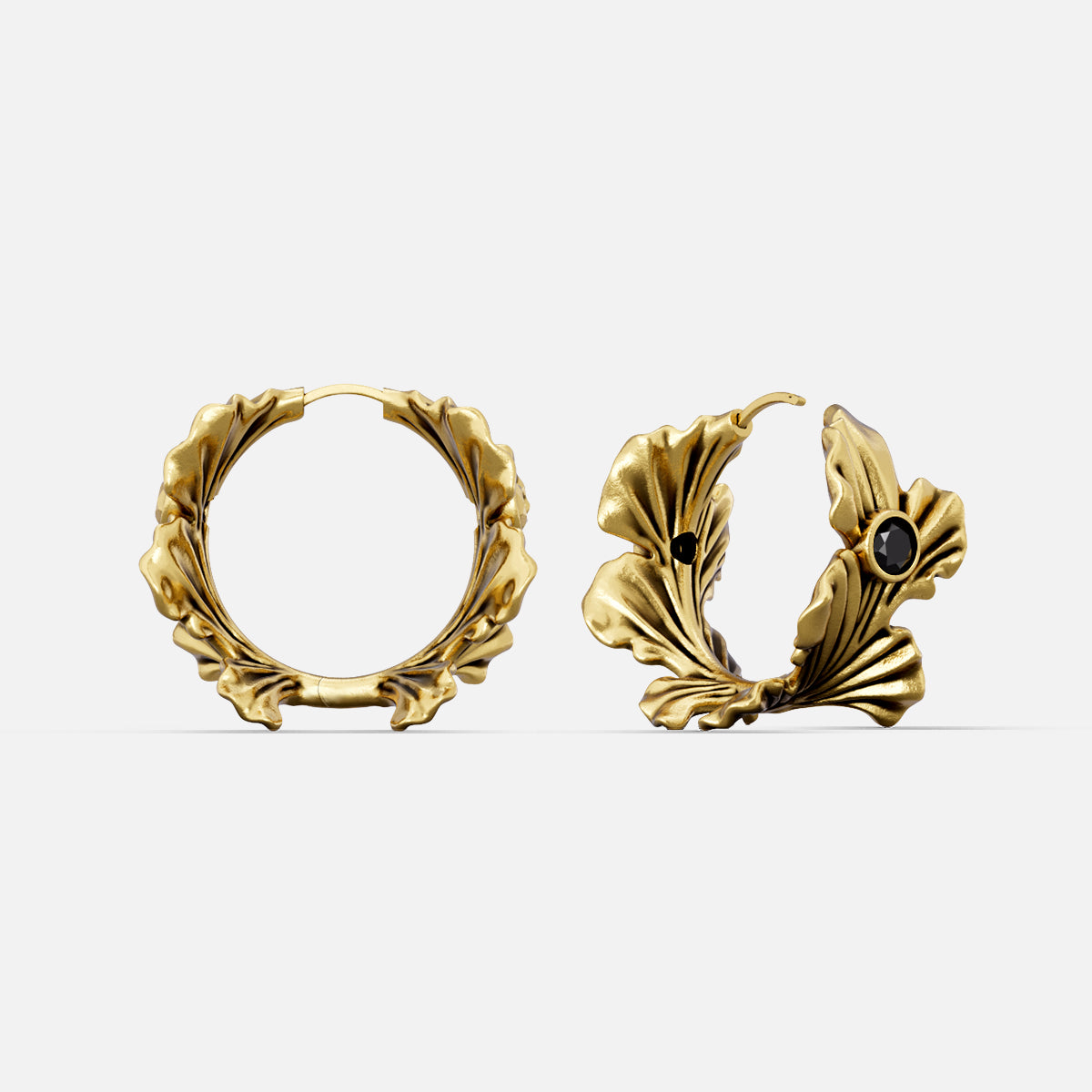 Gold-tone hoop earrings featuring a ginkgo leaf design accented with a small black stone, front and side view