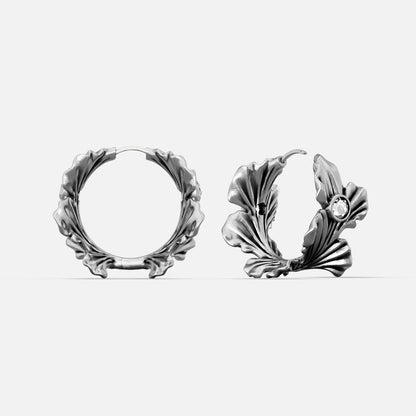 Silver-tone hoop earrings with ginkgo leaf motif and a small clear stone accent, front and side view