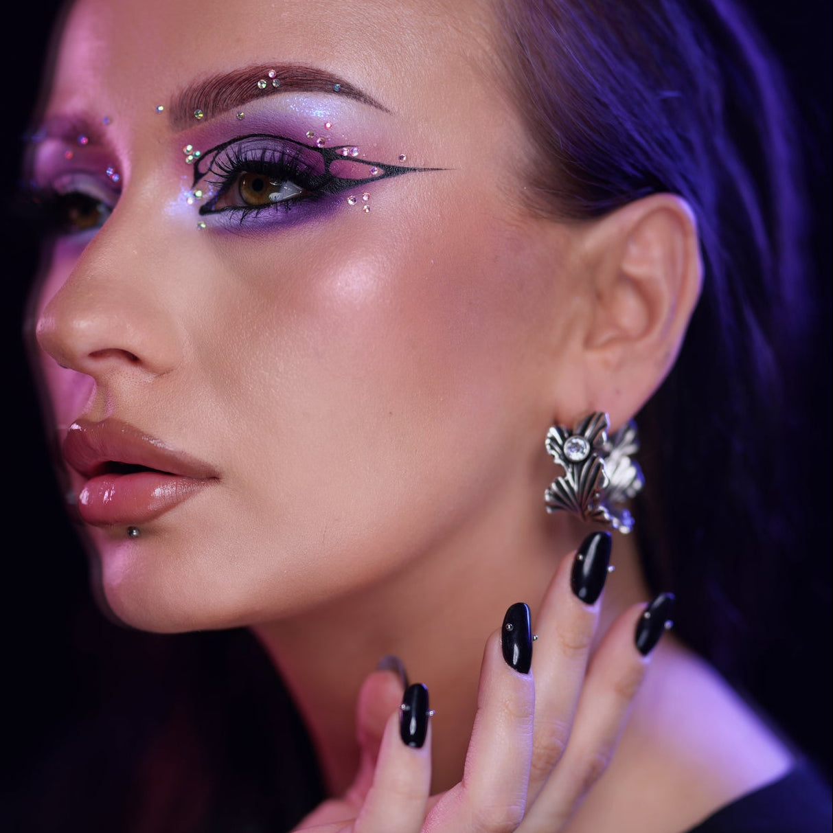 Side profile of a model wearing a botanical ginkgo leaf earring in silver-tone with a clear stone detail
