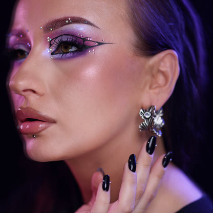 Side profile of a model wearing a botanical ginkgo leaf earring in silver-tone with a clear stone detail