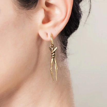 Model wearing gold Bound Twin Earrings with bound spike drops and hammered hoop detail