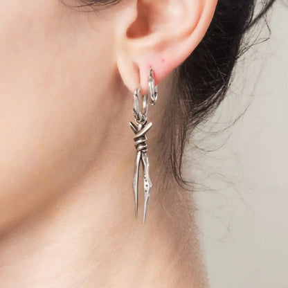 Model wearing silver Bound Twin Earrings with twin spike drops and antiqued brass finish