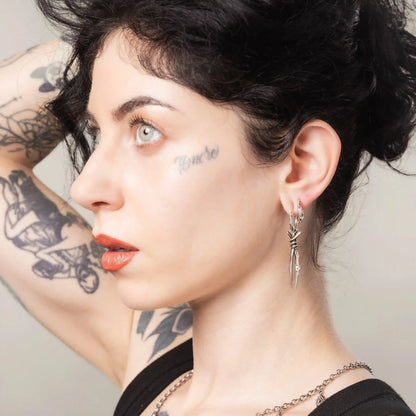 Silver Bound Twin Earrings styled on model with long spike drop silhouette and gothic jewelry mood