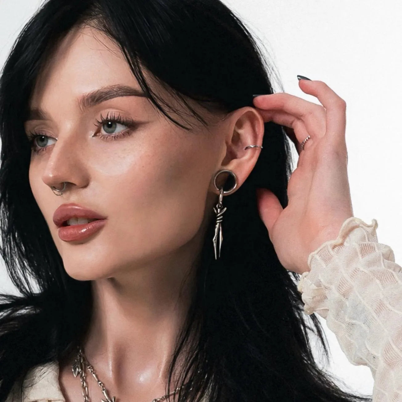Model wearing the silver Bound Twin Earrings with two slim spike drops, twisted wire details, and dark gothic styling.