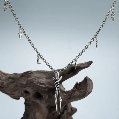Silver Bound Twin Necklace hanging on driftwood with antiqued spike pendant and charm chain