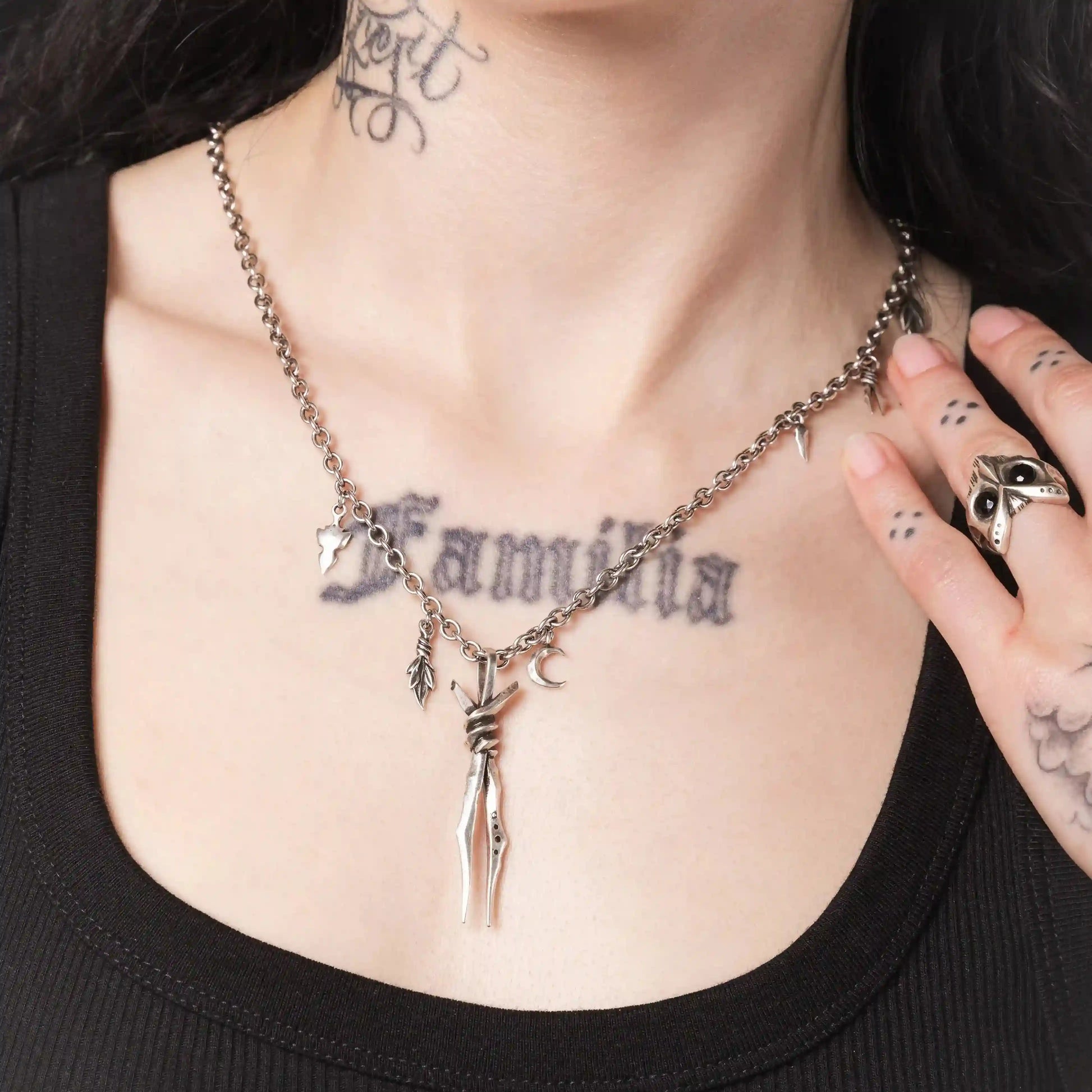 Model wearing the silver Bound Twin Necklace with twin spike pendant and charm chain