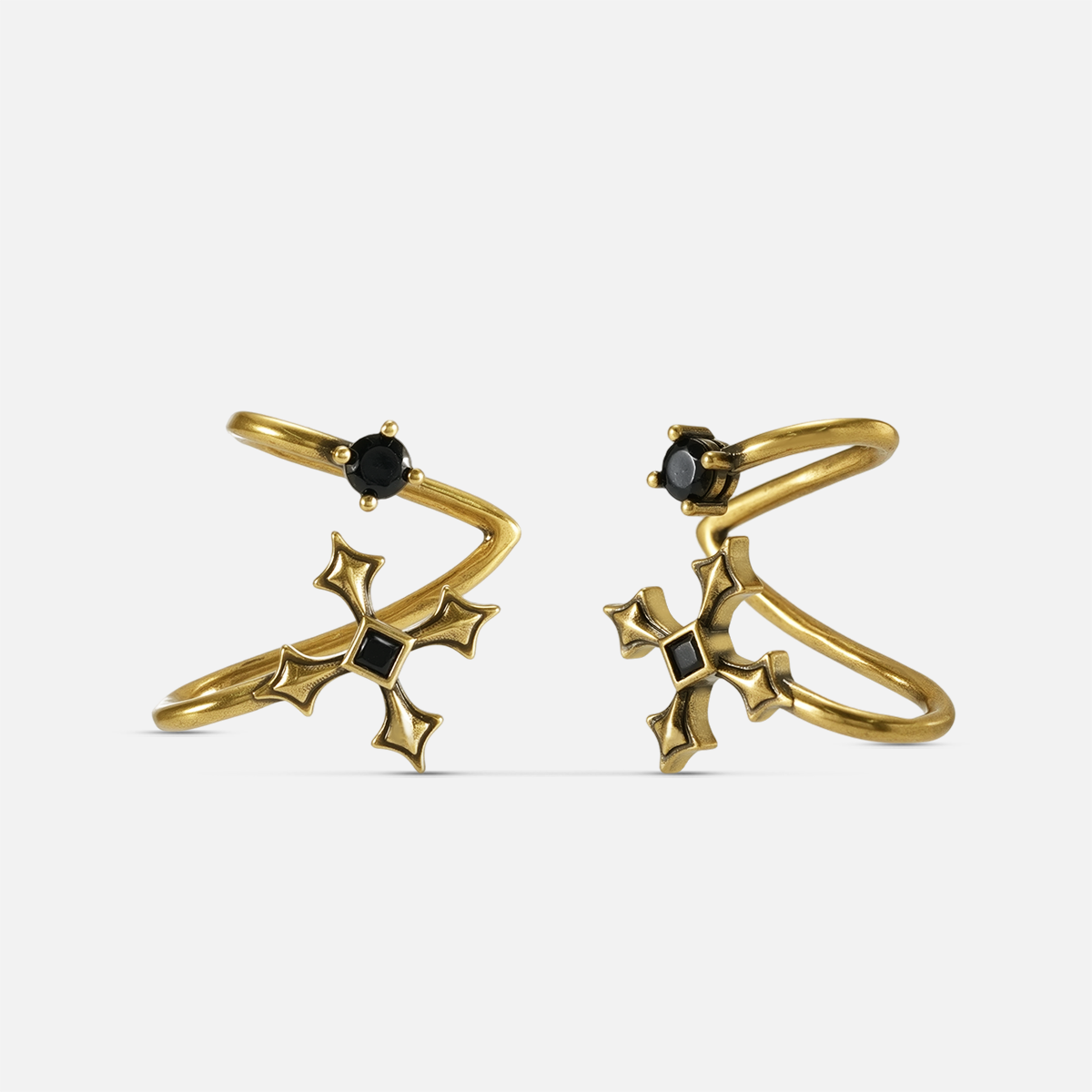 Bound Vestige Ear Cuffs in antiqued 18K gold with black obsidian and cross-inspired metalwork on a white background.