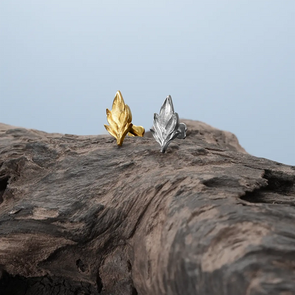Bramble Leaf Ear Studs in gold and silver displayed on driftwood with botanical relic styling
