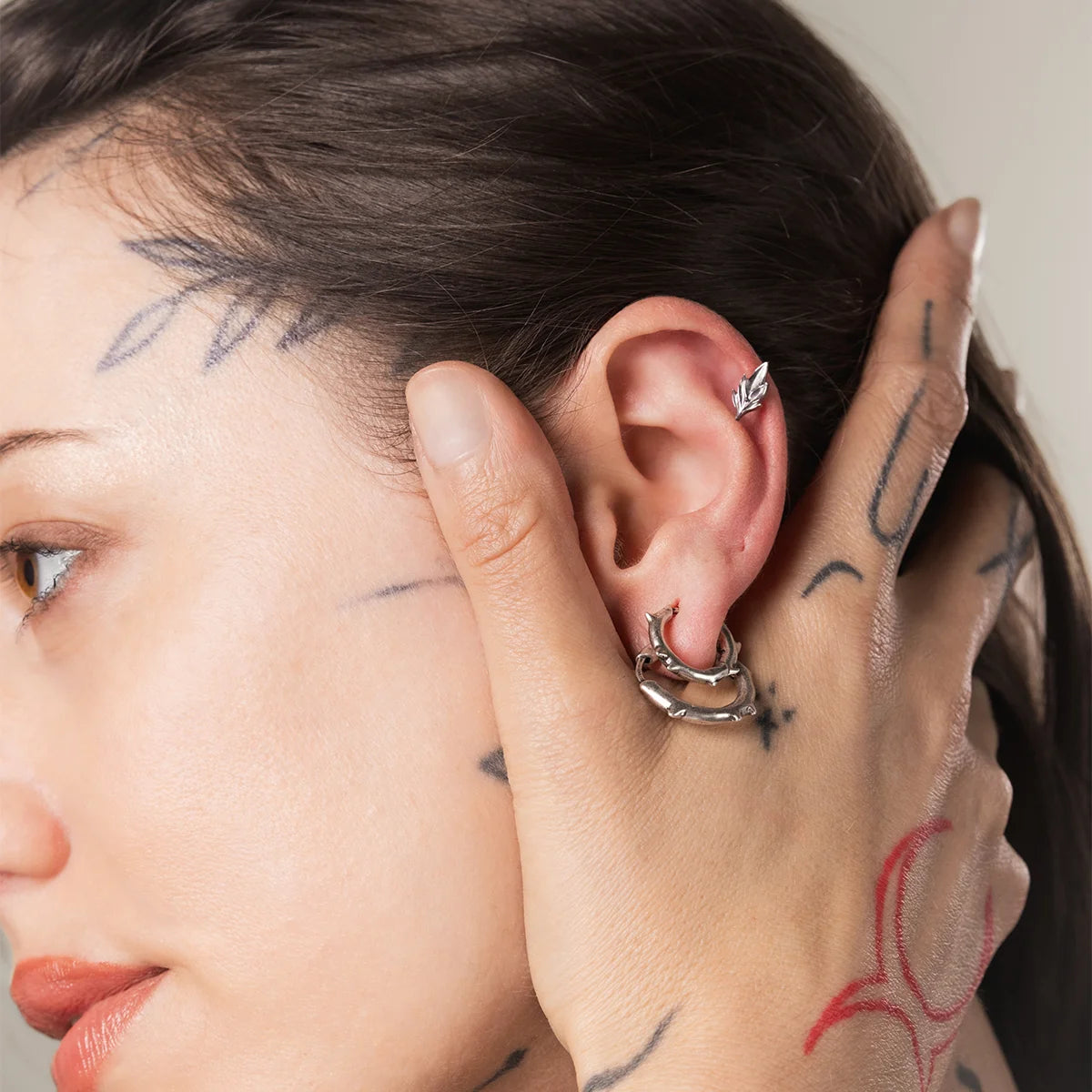 Silver Bramble Leaf Ear Studs styled on ear with woodland inspired piercing jewelry