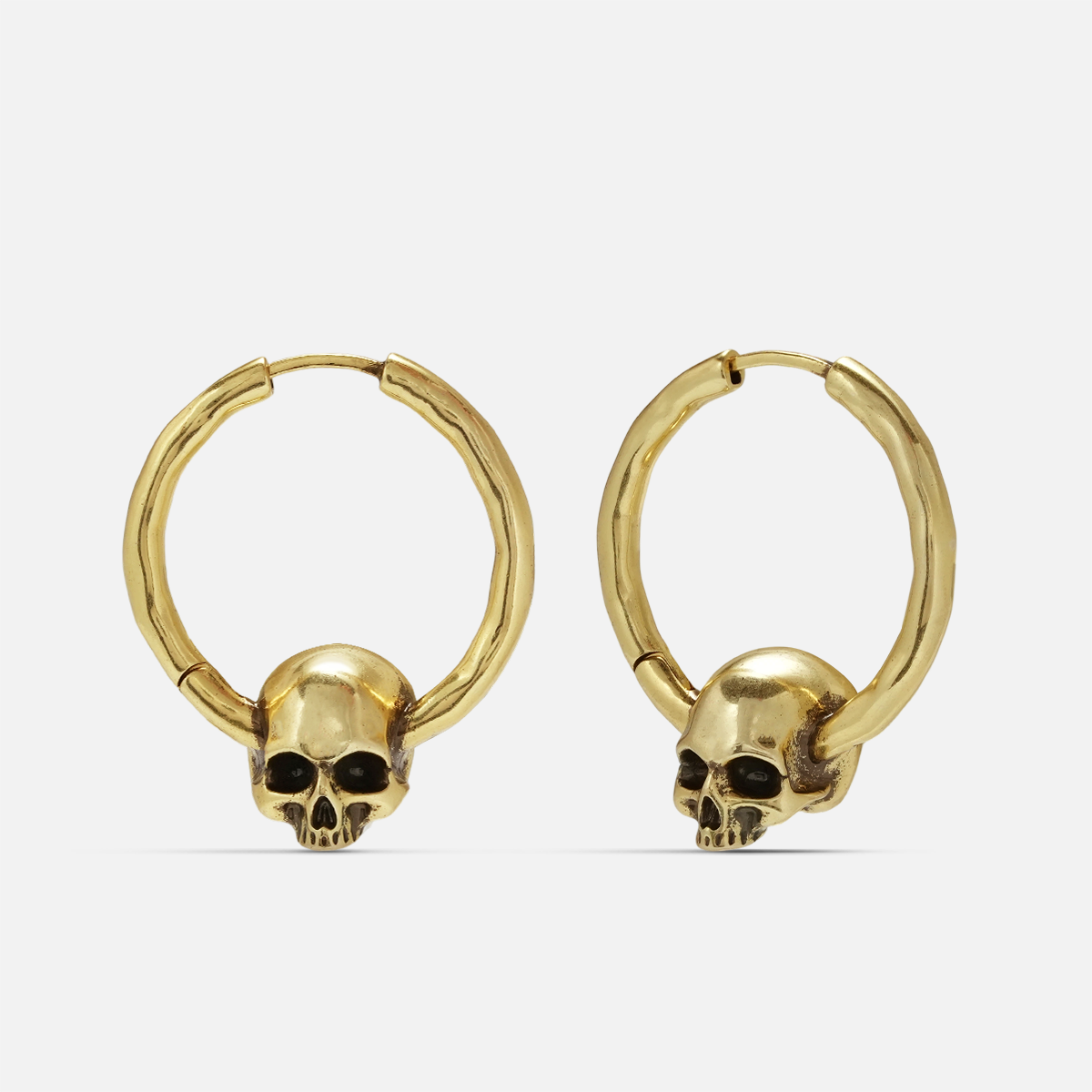 Brave skull earrings in gold, shown as a pair in a front view with skull charm details