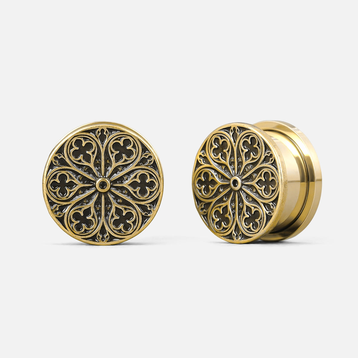 Pair of gold-tone ear plugs featuring a cathedral rose window motif, shown from front and side