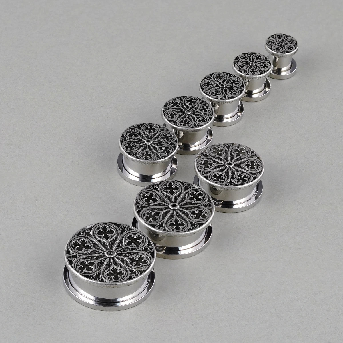 Cathedral Rose plugs in graduated sizes arranged on a light surface
