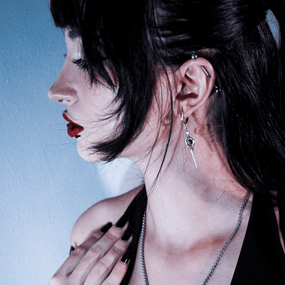 Celestial Orbit Earrings in 925 sterling silver, worn in side profile with black hair, red lipstick, and a blue background.
