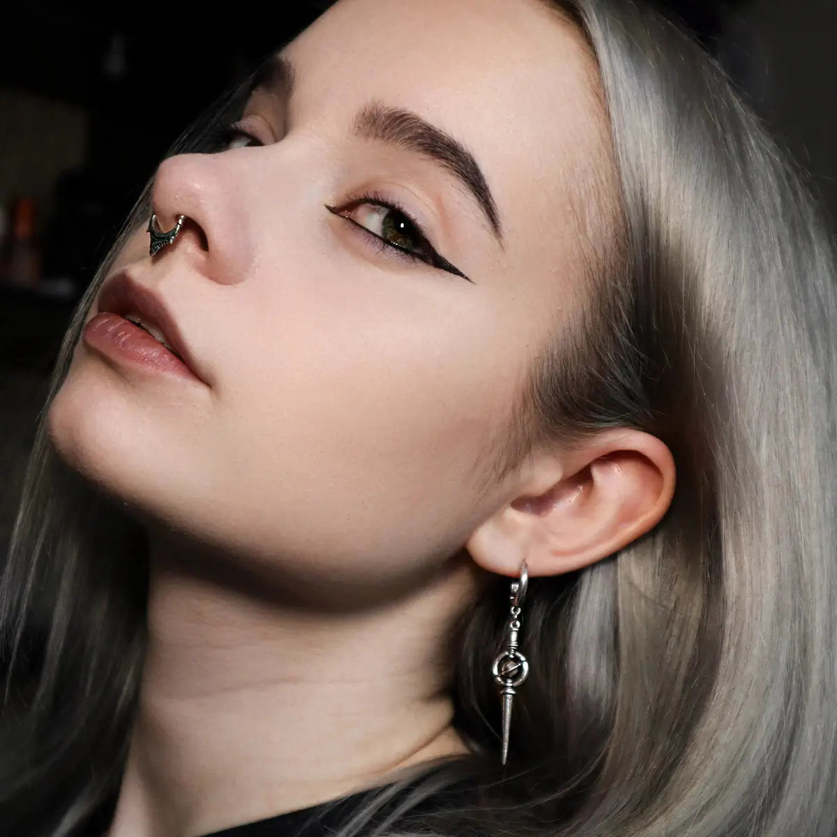 Celestial Orbit Earrings in 925 sterling silver, worn in a blonde side portrait with a black top and clean winged eyeliner.