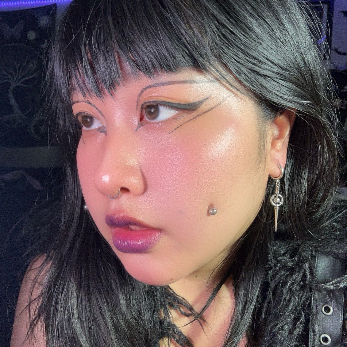 Celestial Orbit Earrings in 925 sterling silver, worn in a close selfie with gray-black hair, graphic eyeliner, and pink ambi