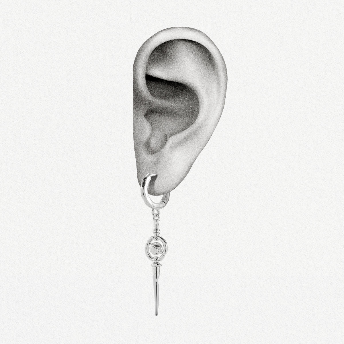 Silver-tone hoop earring with spike and orbit ring charm shown on an illustrated ear model