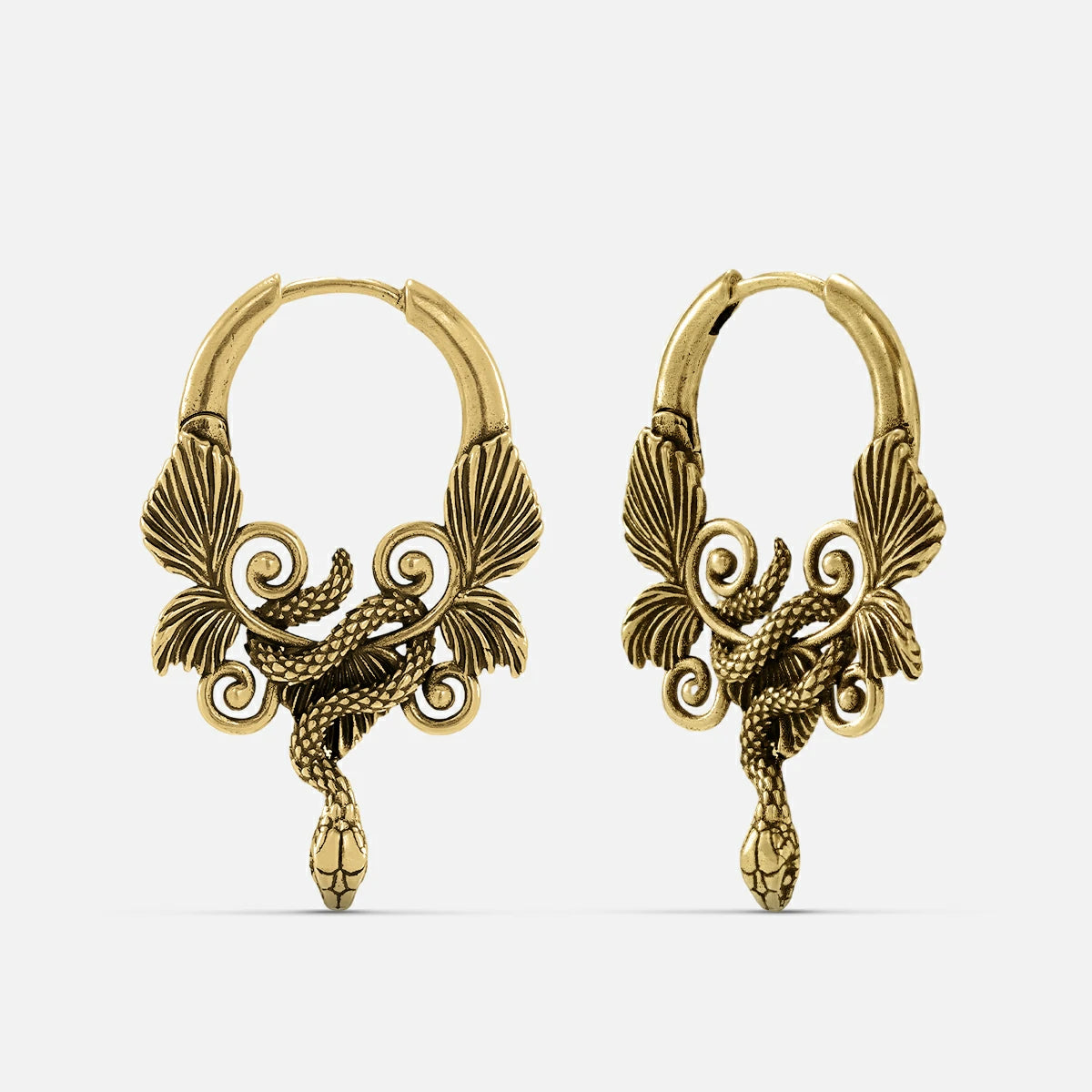 Pair of antique gold-tone hoop earrings featuring a coiled serpent and wing design, front view