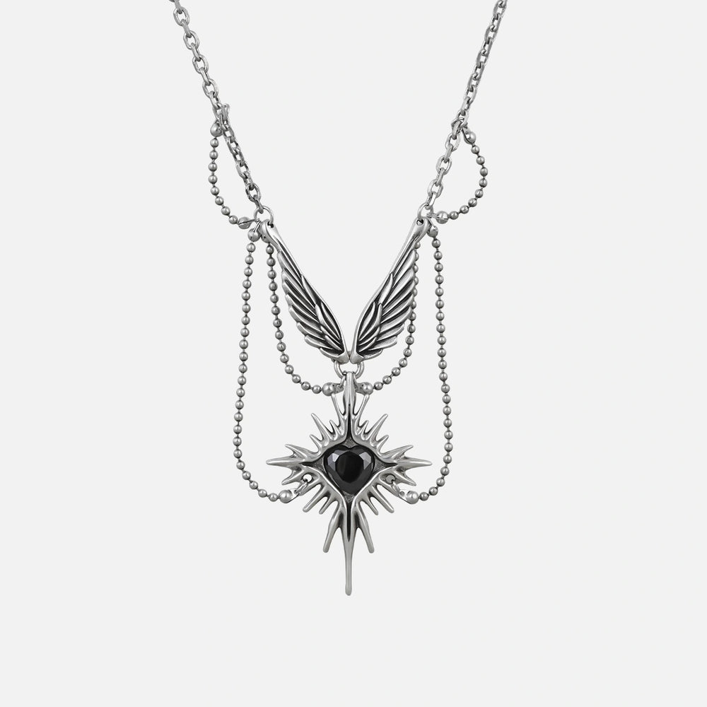 Silver-tone layered necklace with a winged eye starburst pendant and dangling spike
