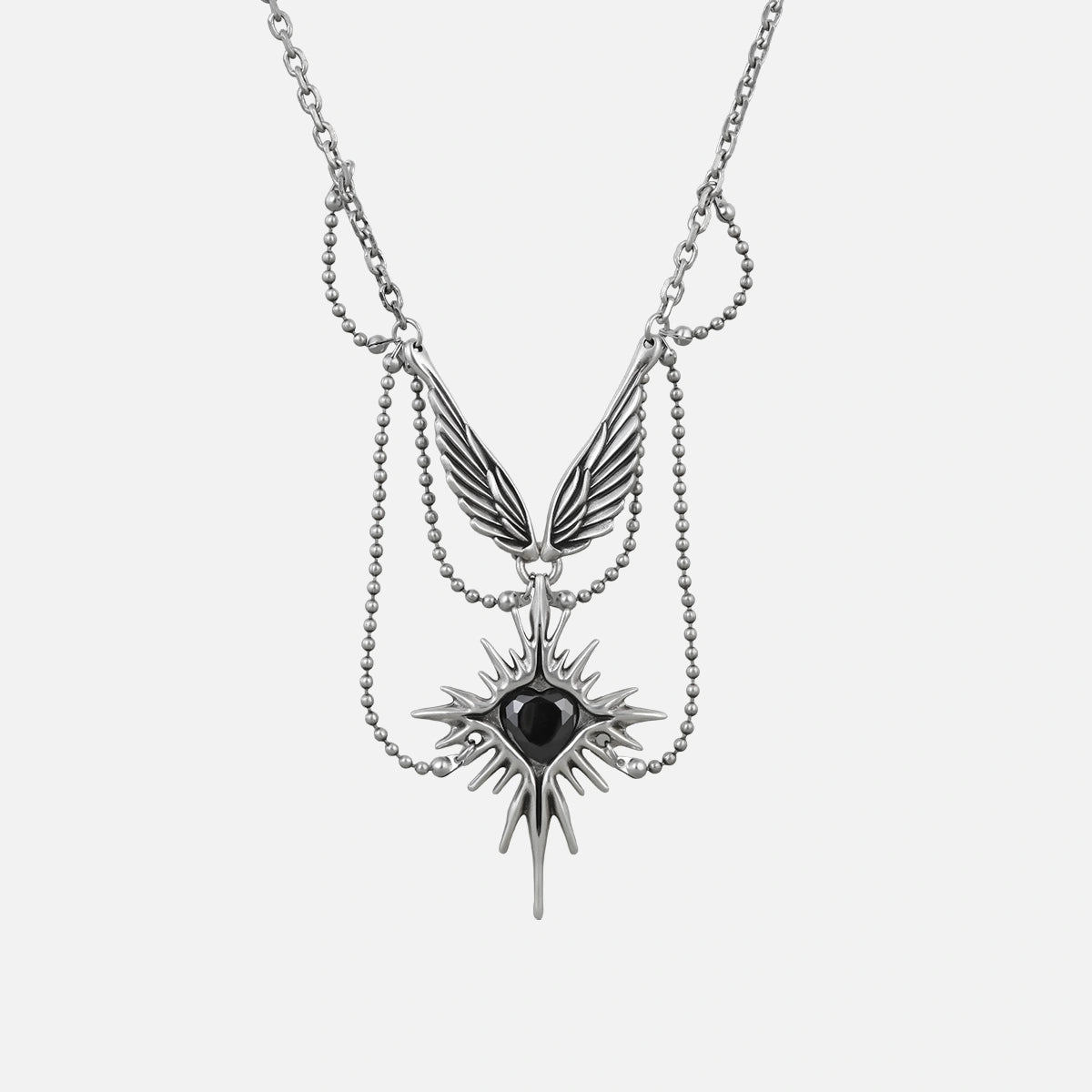Silver-tone layered necklace with a winged eye starburst pendant and dangling spike