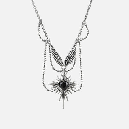 Silver-tone layered necklace with a winged eye starburst pendant and dangling spike