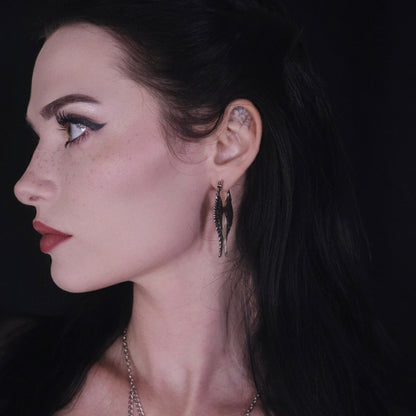 Model wearing a pair of long silver Celestial Wing earrings