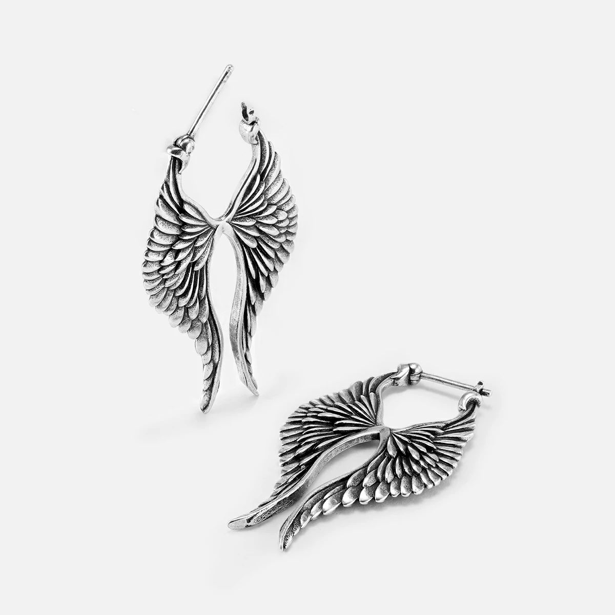 Pair of silver Celestial Wing earrings shown upright and lying flat