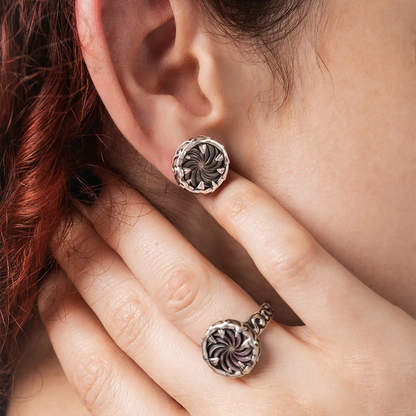 Close-up of Charybdis Maw abalone shell stud earrings showing the spiral design worn on ear.