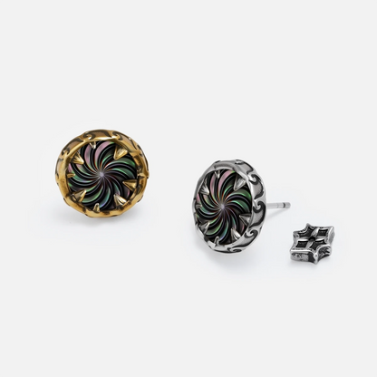 Silver and gold Charybdis Maw Ear Studs shown together, featuring abalone shell spiral centers, tooth-like rims, and flat back posts.