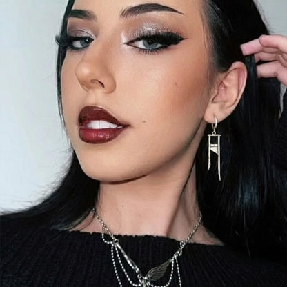 Model wearing a silver Chic Guillotine hoop earring with long geometric drop