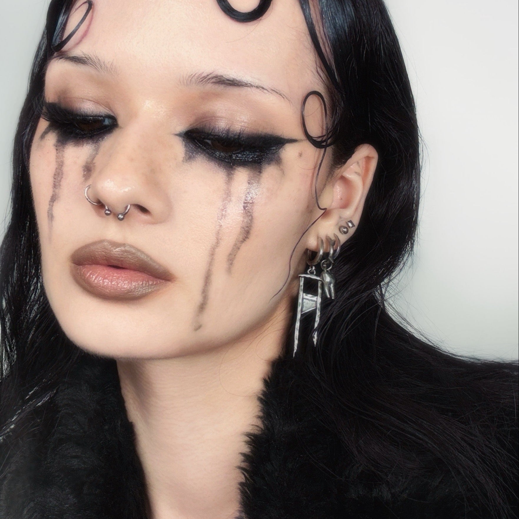Model wearing a silver Chic Guillotine hoop earring with pointed pendant