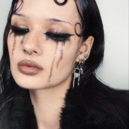 Model wearing a silver Chic Guillotine hoop earring with pointed pendant