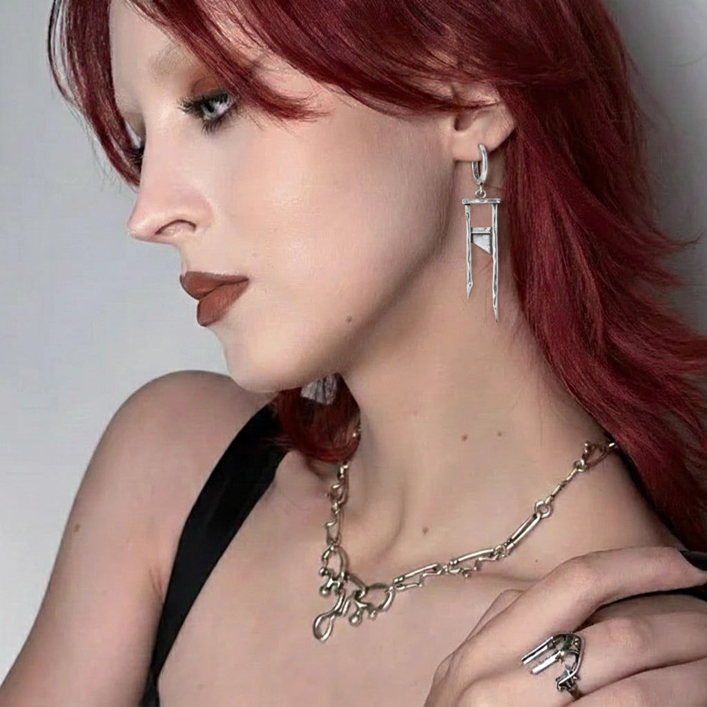 925 silver Chic Guillotine earring worn by a model with red hair, paired with a layered silver-tone necklace