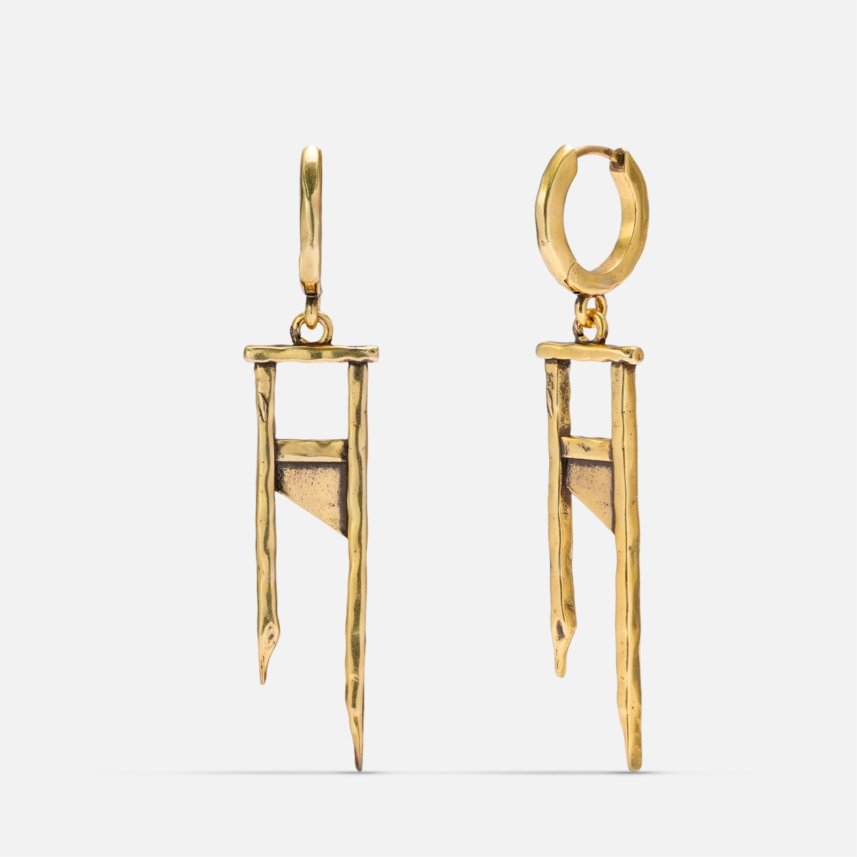 Pair of gold-tone hoop earrings with hammered guillotine-shaped charms, displayed against a plain background