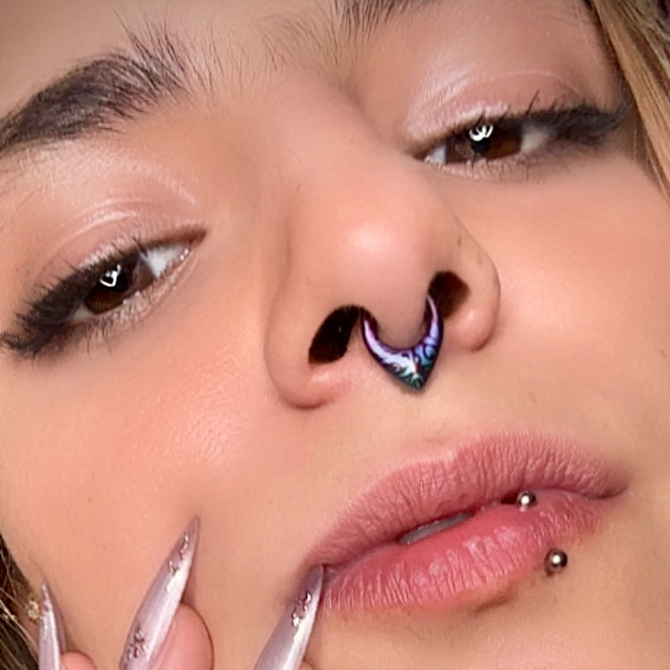 Close-up of a model wearing a purple and teal patterned septum clicker with a labret piercing visible