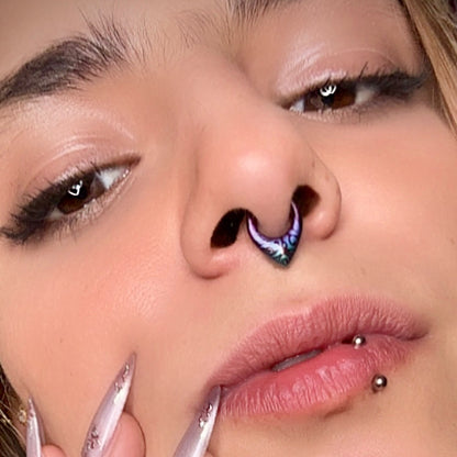 Close-up of a model wearing a purple and teal patterned septum clicker with a labret piercing visible