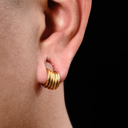 Close-up of a gold-tone stacked hoop earring worn in an ear, side view