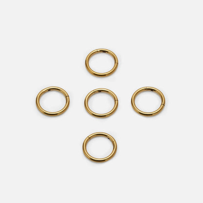Five gold Chromatic Loop rings arranged on a white background