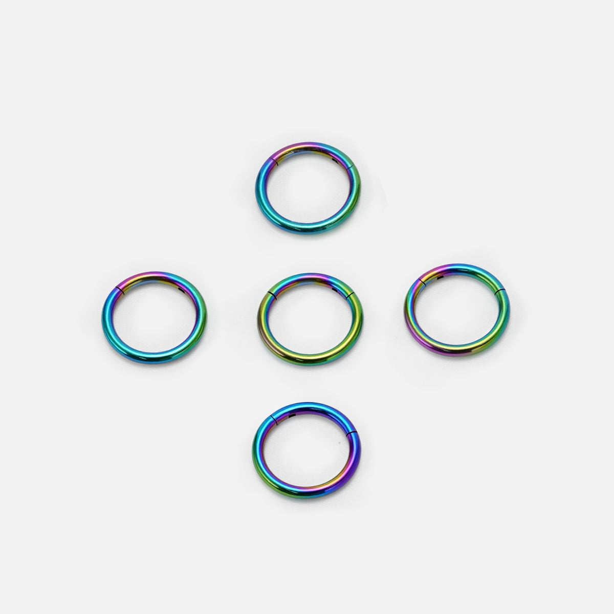 Five rainbow Chromatic Loop rings arranged on a white background