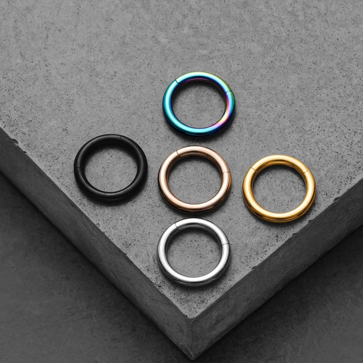 Black, rainbow, rose gold, gold, and silver Chromatic Loop rings displayed together