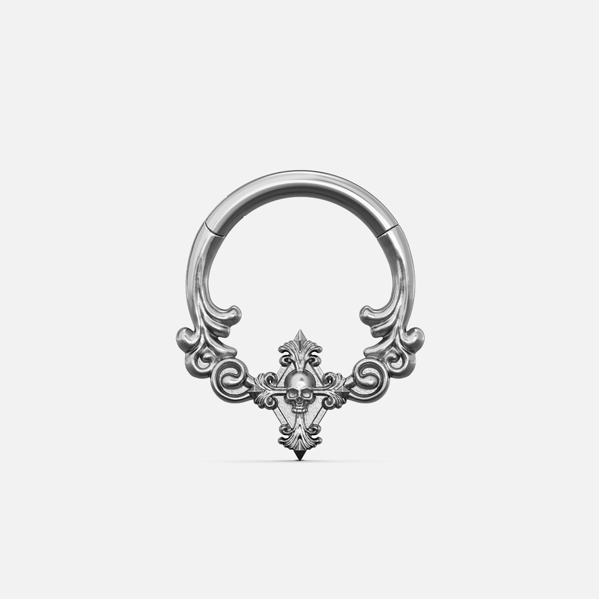 Silver-tone septum clicker ring with ornate scrollwork and a small skull motif, front view on white background